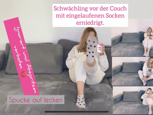 Schwächling vor der Couch mit eingetragenen Socken erniedrigt.